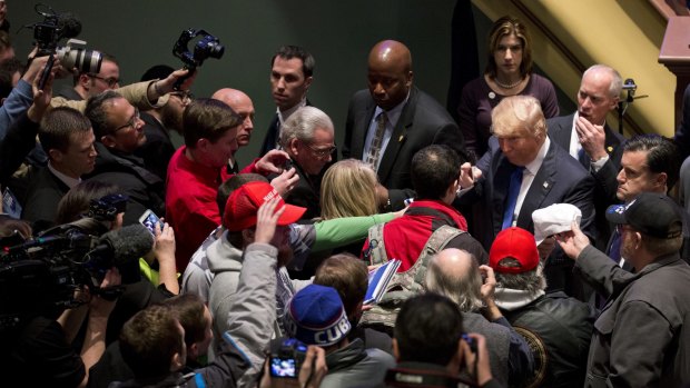 Republican presidential candidate Donald Trump, far right, signs autographs after a campaign event on the campus of Drake University on Thursday.