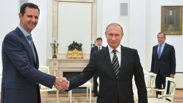 Putin shakes hand with Syrian President Bashar Assad in Moscow in October 2015.