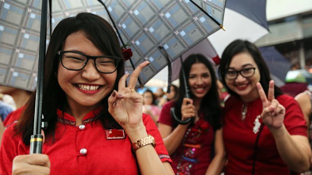 National League for Democracy (NLD) party supporters pose celebrate outside the party headquarters in Yangon on Sunday. 