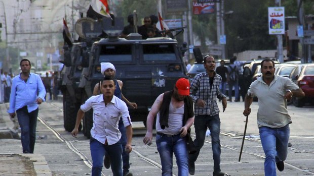 Crackdown: Police pursue protesters in Cairo in June 2014.