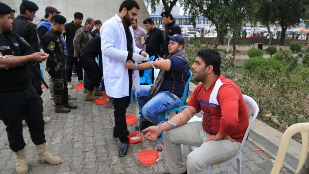 People donate blood for wounded Iraqi security forces fighting against the Islamic State group in Tahrir Square, Baghdad, Iraq, on Saturday.