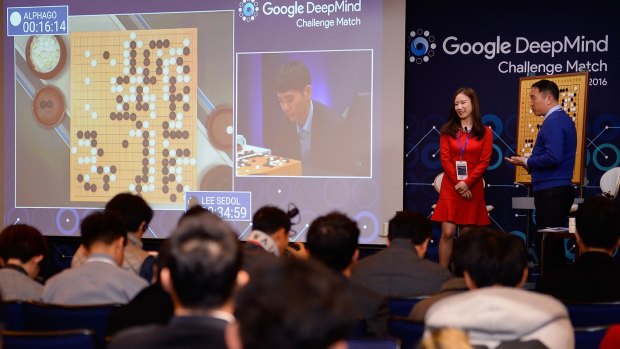 An audience watches a screen showing the live broadcast of the Google DeepMind challenge match in Seoul.