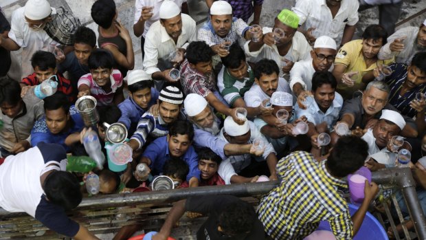 Indian Muslims jostle for drinks distributed at Nakhoda Mosque after breaking their fast in Kolkata, India, on Tuesday.