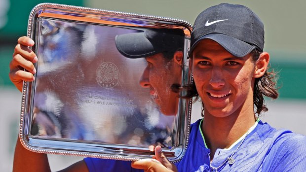 Australia's Alexei Popyrin hold the trophy after winning his boys' final match of the French Open.