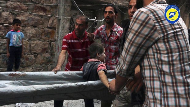 Workers take out a boy, alive, from the rubble, in Aleppo, Syria.