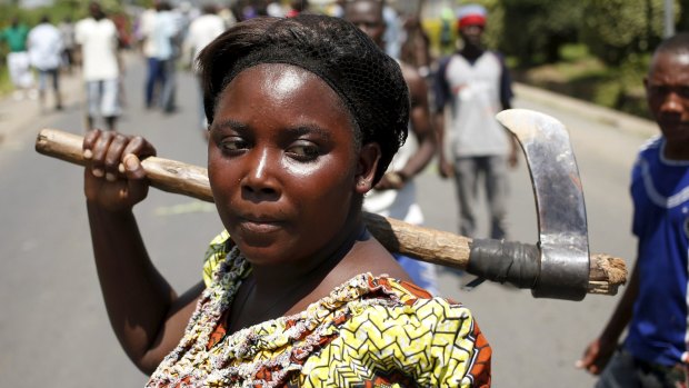 A female protester holds an axe during a protest against Burundian President Pierre Nkurunziza's decision to run for a third term in Bujumbura, Burundi on Wednesday.
