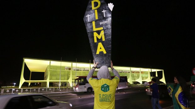 A pro-impeachment protester holds a mock coffin outside the Planalto presidential palace in Brasilia on Tuesday.