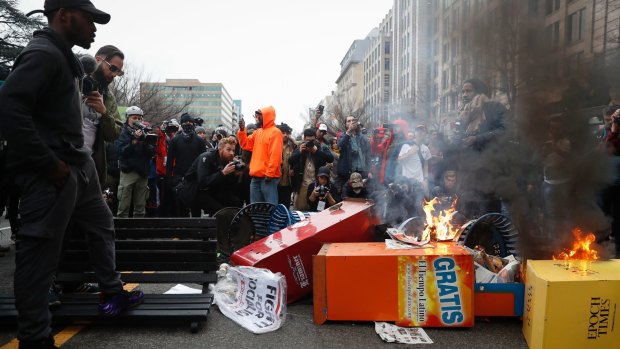A pile of burning newspaper machines at a demonstration against Donald Trump's inauguration in Washington.