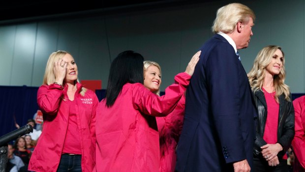 Republican presidential candidate Donald Trump on stage with female supporters during a campaign rally on Friday.