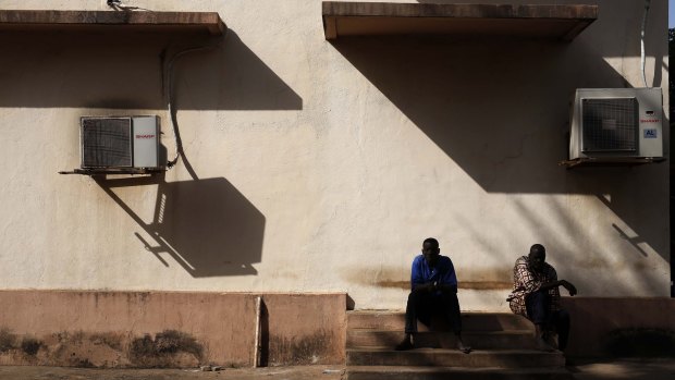 Hospital workers sit outside the morgue of the Gabriel Toure hospital in Bamako, Mali, on Sunday.