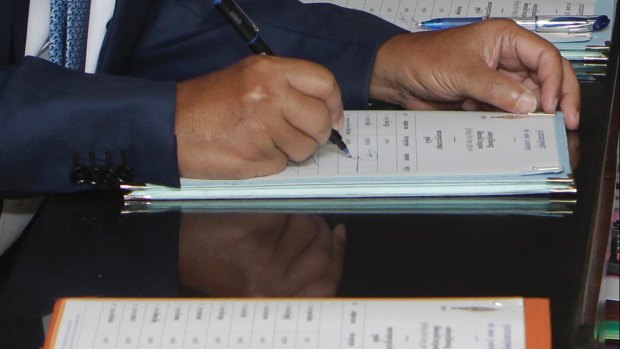 Cambodian PM Hun Sen registers his name before a meeting at the National Assembly. 