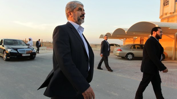 Khalid Mishal and his security detail walk the streets of Doha, Qatar, in February 2013.  