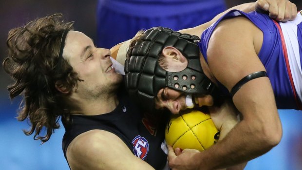 Caleb Daniel of the Bulldogs (right) is tackled by Dylan Buckley of the Blues.