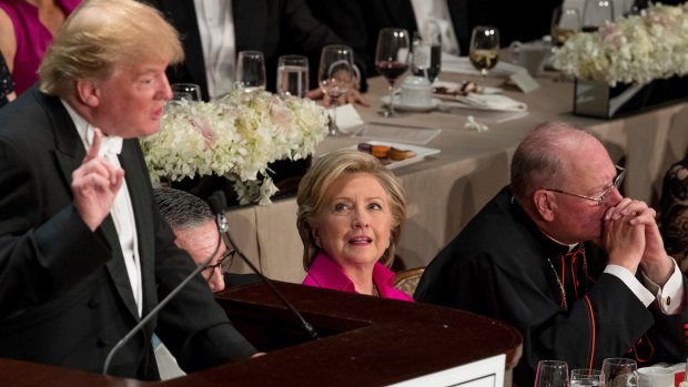 Hillary Clinton and Cardinal Timothy Dolan, Archbishop of New York,  listen as Donald Trump speaks at the Alfred E. Smith Memorial Foundation Dinner in New York on Thursday.