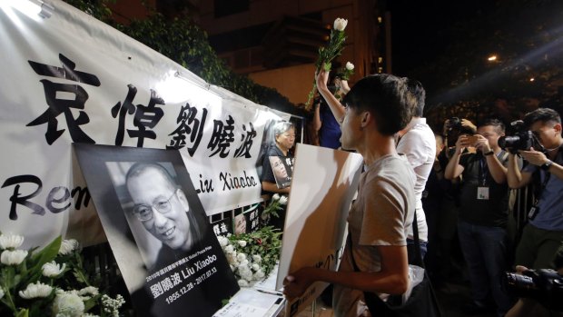 Protesters mourn jailed Chinese Nobel Peace laureate Liu Xiaobo during a demonstration outside the Chinese liaison office in Hong Kong.