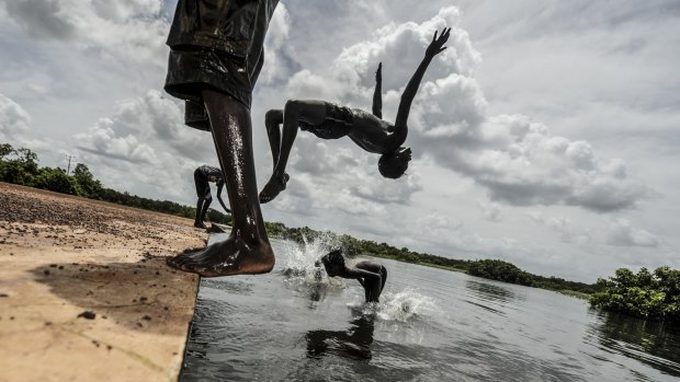 Children play in the flooded community of Palumpa, Northern Territory.