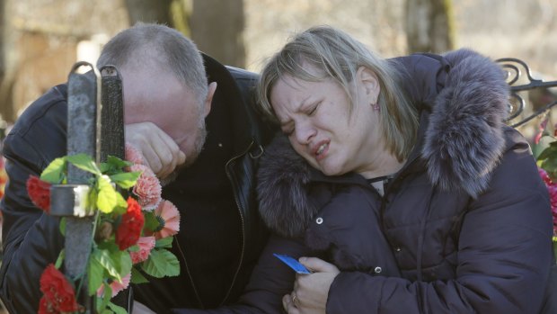 Nina Lushchenko's nephew Pavel and daughter Veronika at her grave in Sitnya on Thursday. 