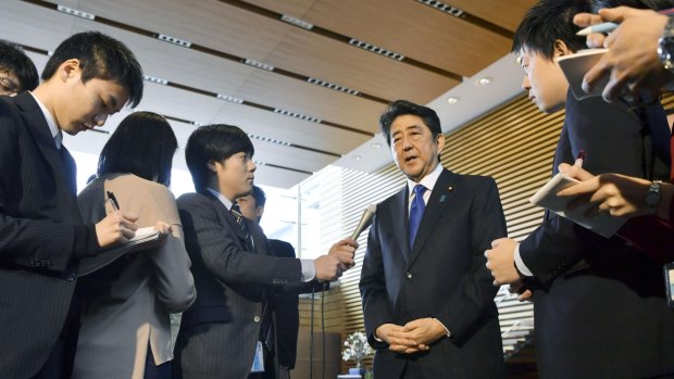 Japanese Prime Minister Shinzo Abe, centre, speaks to the reporters, following North Korea's missile launches in Tokyo, on Monday.