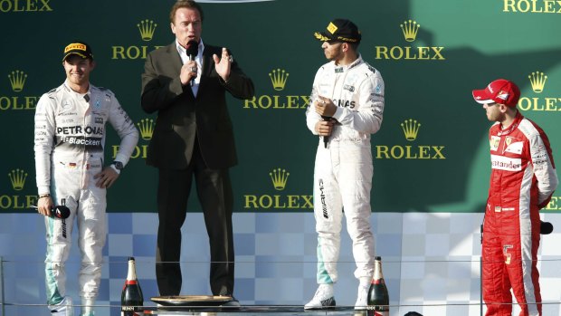 Second-placed Nico Rosberg, former actor Arnold Schwarzenegger, winner Lewis Hamilton and third-placed Sebastian Vettel of Germany on the podium after the race.