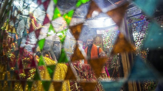 A devotee reflected in a mirror at a temple that stands at a site purported to have been the banks of the mystical Saraswati river in Adi Badri, Haryana.