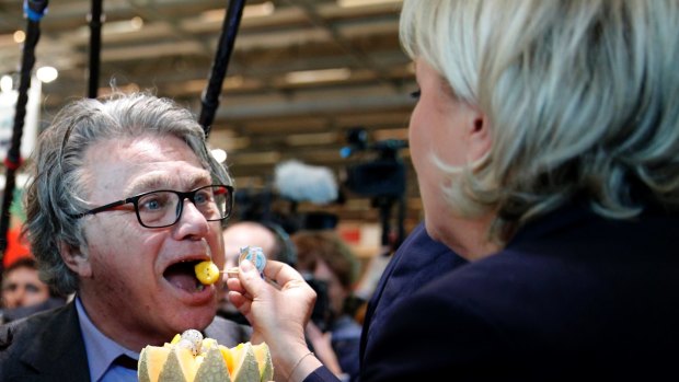 Marine le Pen feeds far-right lawyer Gilbert Collard with a piece of melon at the French Caribbean islands stand as she visits the Agriculture Fair in Paris on Tuesday. 