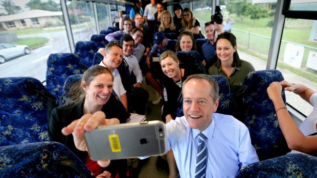 Opposition Leader Bill Shorten takes a selfie with media on the campaign bus.