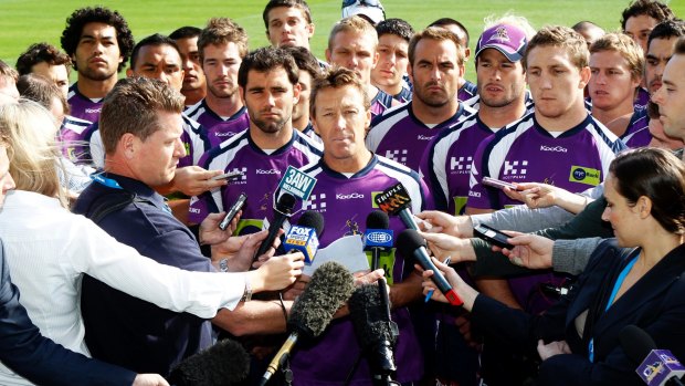 United front: Surrounded by all 22 players, Melbourne Storm coach Craig Bellamy addresses the media after the Storm were penalised for cheating the salary cap in 2010.