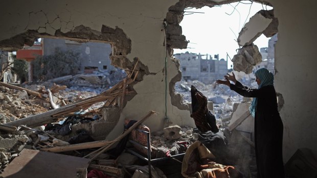 Sort through the rubble of a home destroyed during the Israel offensive in Gaza last August.