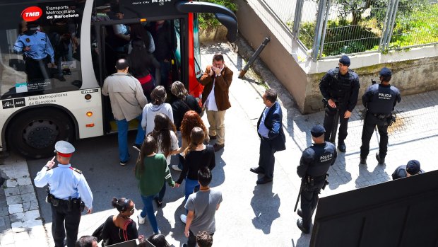 Students, believed to be from the same classroom where a pupil allegedly killed a teacher and injured four other classmates, leave the Joan Fuster high school in Barcelona, Spain. 