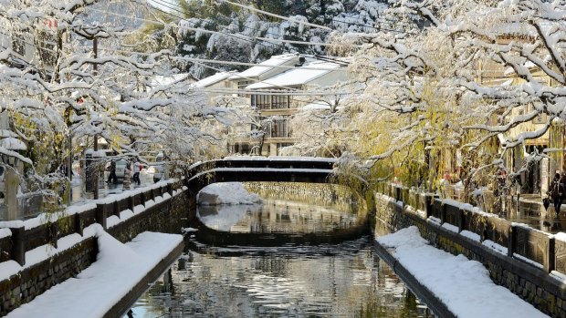 A bridge in Kinosaki Onsen covered by snow.