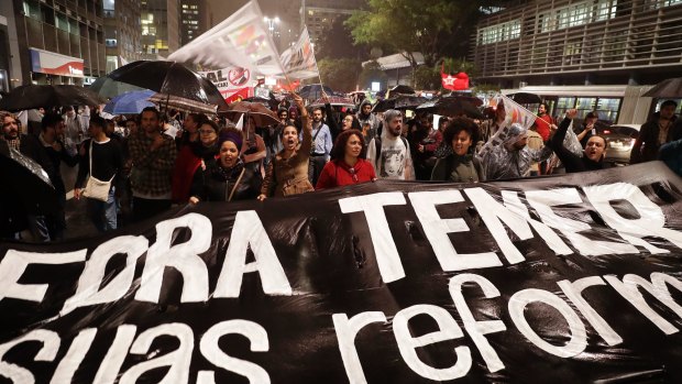 Demonstrators march carrying a banner that reads in Portuguese "Get out Temer and your reforms" in Sao Paulo on Thursday.