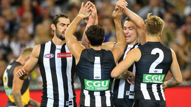 Alex Fasolo of the Magpies is congratulated by teammates after kicking a goal.