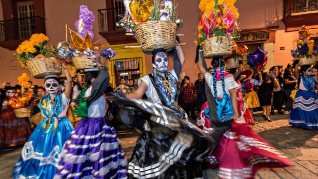 Costumed dancers at a Comparsa, or parade, during the Day of the Dead festival.