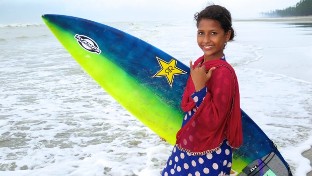 Bangladeshi kid surfers on the beach in Cox's Bazar, Bangladesh.