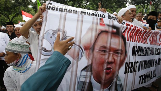 Muslim protesters hold a banner calling for the arrest of Jakarta Governor Basuki Tjahaja Purnama, popularly known as Ahok, outside City Hall in Jakarta.