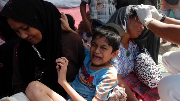 Injured people receive treatment outside a hospital in the quake-devastated area.