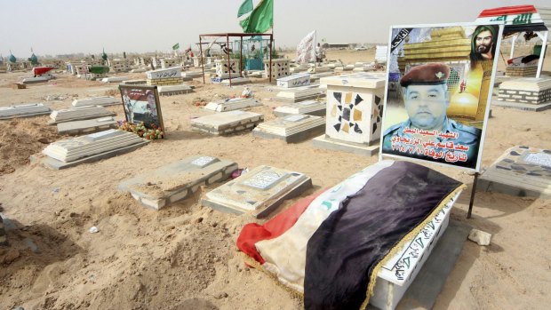 An Iraqi soldier's grave is marked with the national flag at the cemetery. Thousands of Shiite soldiers and militiamen have been killed since Islamic State militants captured Mosul and swept south in June.
