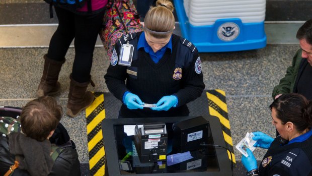 Transportation Security Administration (TSA) officers check passenger's identification at a security checkpoint at Ronald Reagan National Airport (DCA) in Washington, D.C.