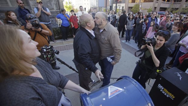 Mark Lindsay, left, and Tom Kerns kiss after mailing a resignation letter in Salt Lake City on Saturday. 
