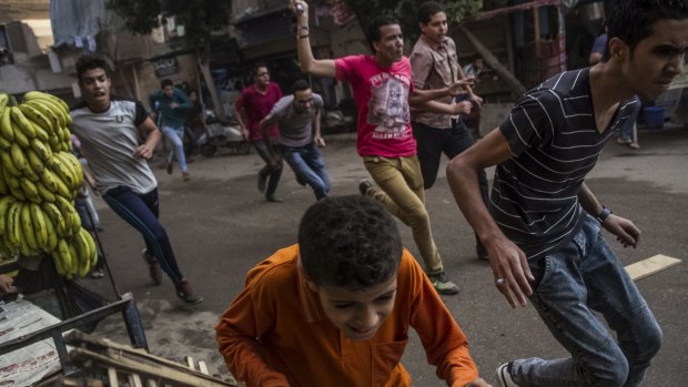 Supporters of the Muslim Brotherhood and bystanders run away from the Egyptian security forces during clashes on Tuesday.