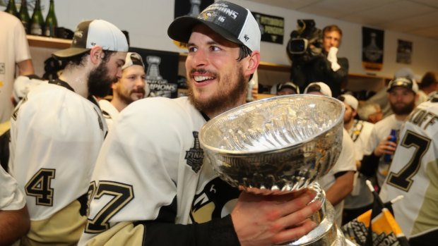Trophy moment: Sidney Crosby celebrates with the Stanley Cup in the locker room.