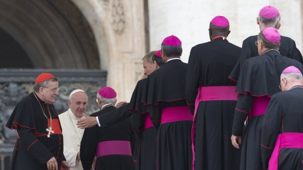 US Cardinal Raymond Leo Burke, left, stands by Pope Francis saluting bishops, at the end of weekly general audience in St Peter's Square earlier this month.