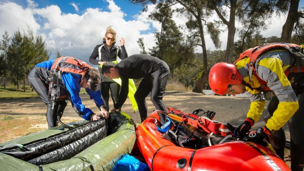 Mont Adventure Racing Team members Lee Rice, Alex Orme, Paul Cuthbert, and Tom Brazier inflate pack rafts at Casuarina Sands.  
