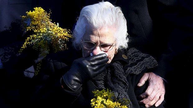 A relative of an Australian victim of the Malaysia Airlines MH17 crash reacts before placing a floral tribute at a memorial that was unveiled outside Parliament House in Canberra on July 17, 2015.