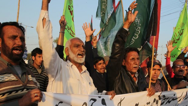Pakistani protesters condemn a bombing at a Shiite mosque that targeted Friday prayers in Karachi, Pakistan.