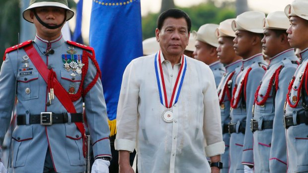 Philippine President Rodrigo Duterte reviews the troops as he leads a flag-raising ceremony in December.