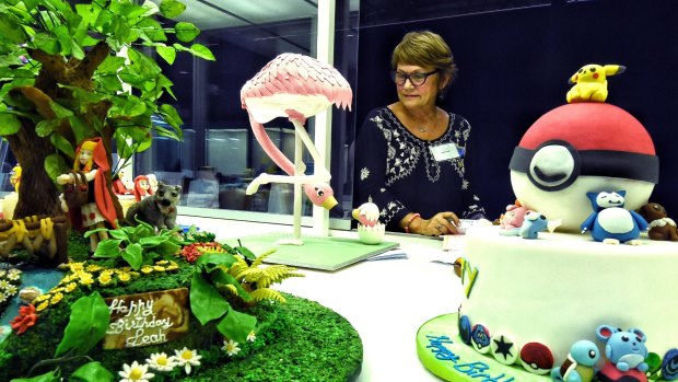 Cake decorating judge Janice Smith carefully inspects entries in the novice cake decorating class for the Royal Easter Show. 