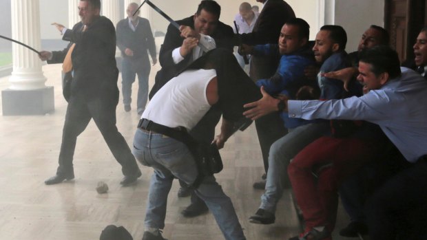 Opposition lawmakers brawl with pro-government militias who are trying to force their way into the Venezuelan National Assembly.