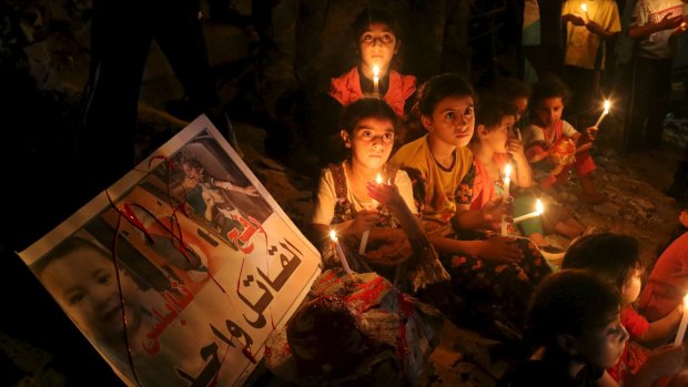 Palestinian children light candles during a rally to remember 18-month-old Palestinian baby Ali Dawabsheh, who was killed after his family's house was set on fire in a suspected attack by Jewish extremists earlier this month. 
