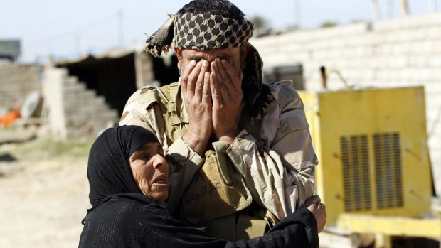 A resident welcomes a relative fighting with the Hashid Shaabi militia, in the town of Al-Alam.